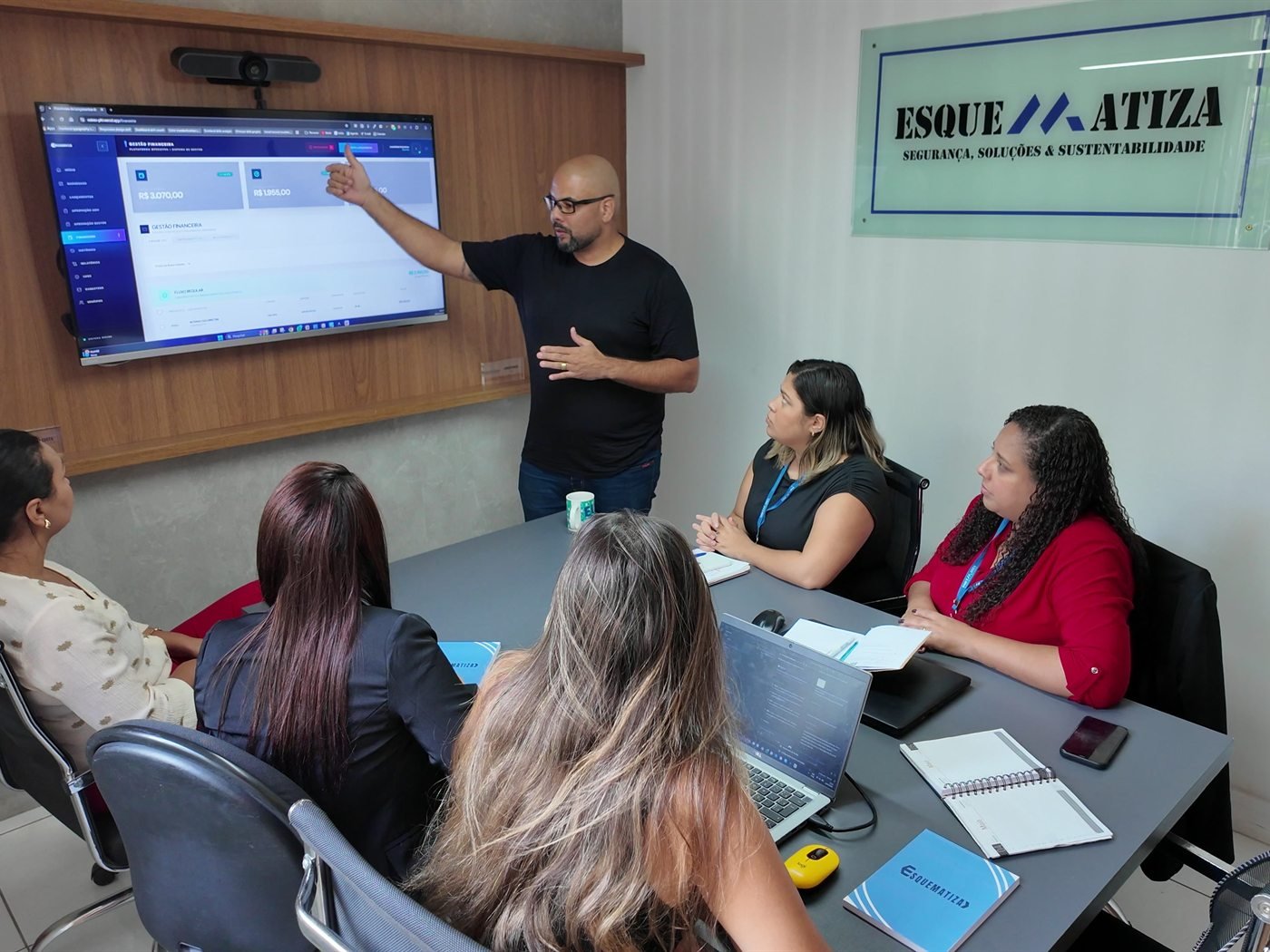 Equipe da Esquematiza analisando painel de gestão de riscos durante reunião na sede.