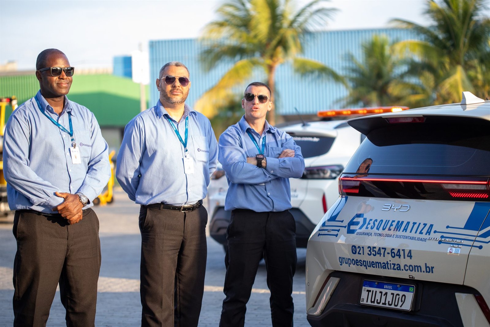 Três supervisores da Esquematiza ao lado das viaturas da frota.