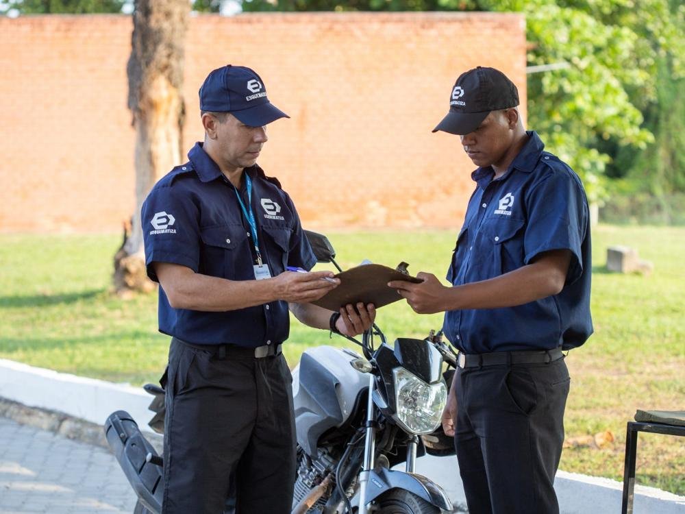 Dois agentes da Esquematiza conferindo informações em prancheta durante o turno.